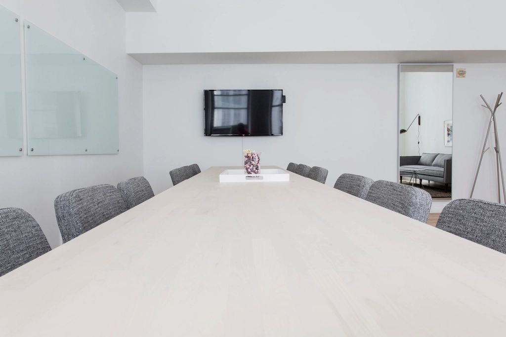 A meeting room with a long table and chairs